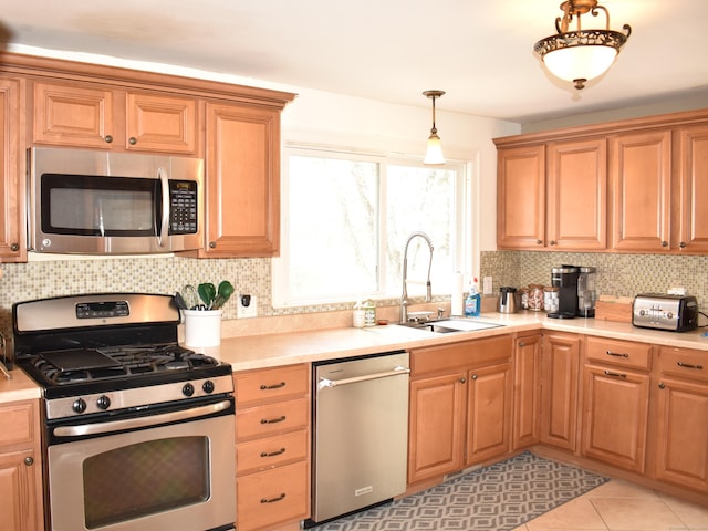 kitchen featuring sink, hanging light fixtures, light tile patterned floors, appliances with stainless steel finishes, and backsplash