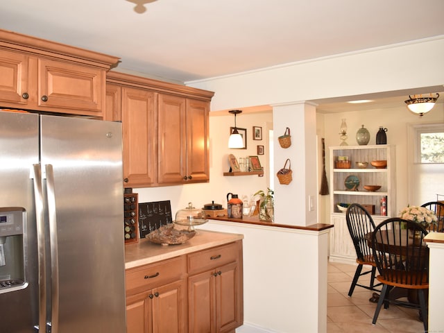 kitchen with hanging light fixtures, light tile patterned floors, and stainless steel fridge