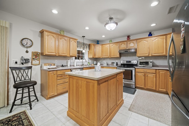 kitchen with pendant lighting, backsplash, a kitchen island, stainless steel appliances, and light tile patterned flooring