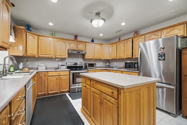 kitchen featuring sink, light tile patterned floors, backsplash, stainless steel appliances, and a center island