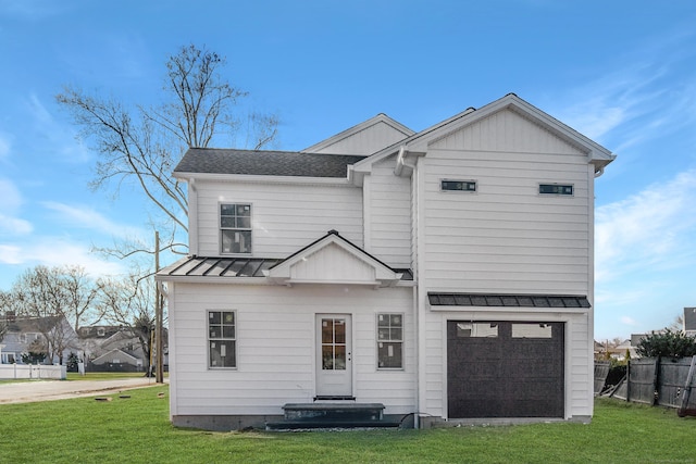 rear view of house with a garage and a lawn