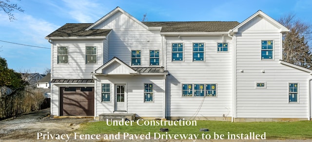 rear view of property featuring a garage