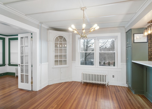 unfurnished dining area featuring radiator heating unit, a chandelier, dark hardwood / wood-style flooring, ornamental molding, and beam ceiling