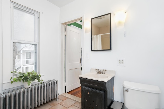 bathroom with vanity, radiator heating unit, and toilet