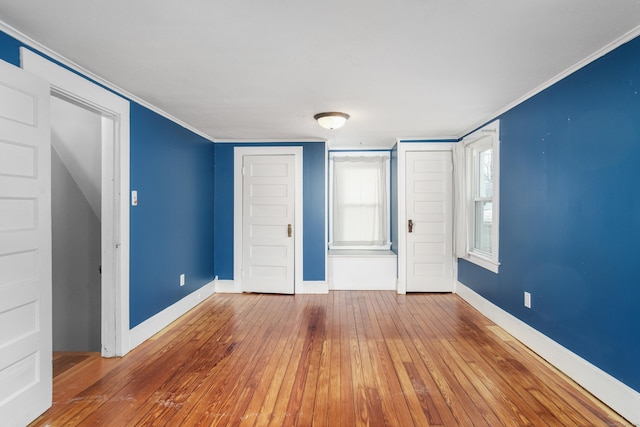 unfurnished bedroom with ornamental molding and hardwood / wood-style floors