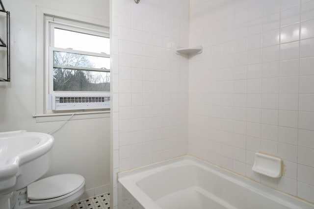 bathroom featuring tiled shower / bath and toilet