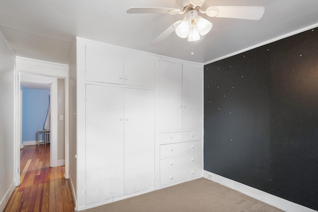 unfurnished bedroom featuring ceiling fan, hardwood / wood-style floors, and a closet