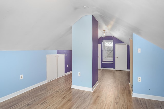 bonus room featuring vaulted ceiling and light wood-type flooring