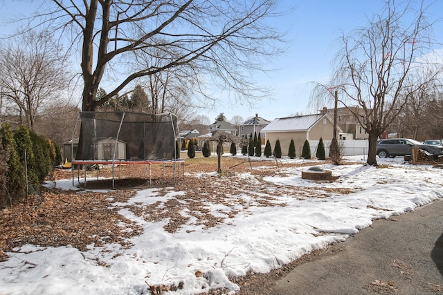 snowy yard with a trampoline and a shed