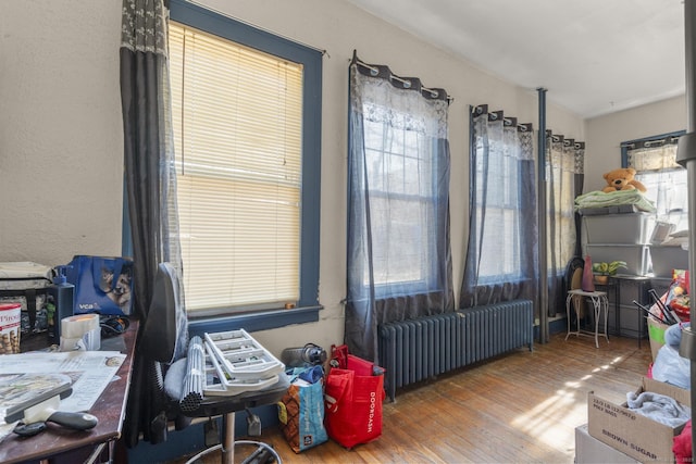 interior space with hardwood / wood-style flooring and radiator heating unit