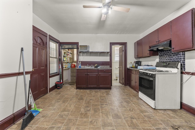 kitchen with tasteful backsplash, ceiling fan, white range with gas cooktop, and sink