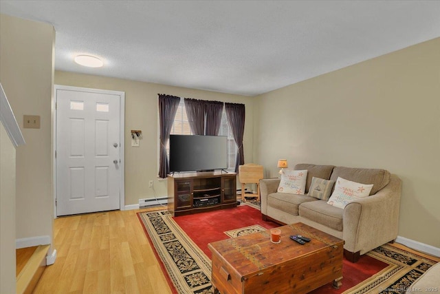 living room featuring a textured ceiling, baseboard heating, and light wood-type flooring