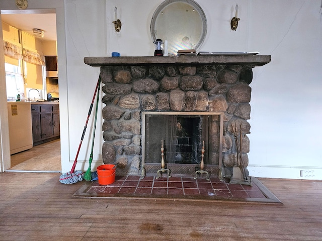 room details with sink, a fireplace, and wood-type flooring