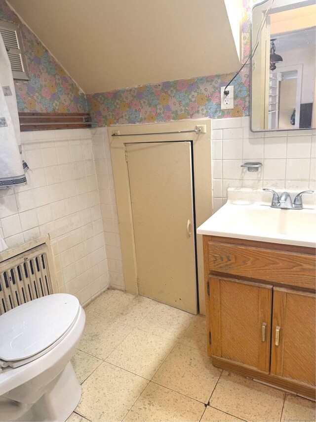 bathroom with vanity, tile walls, and toilet