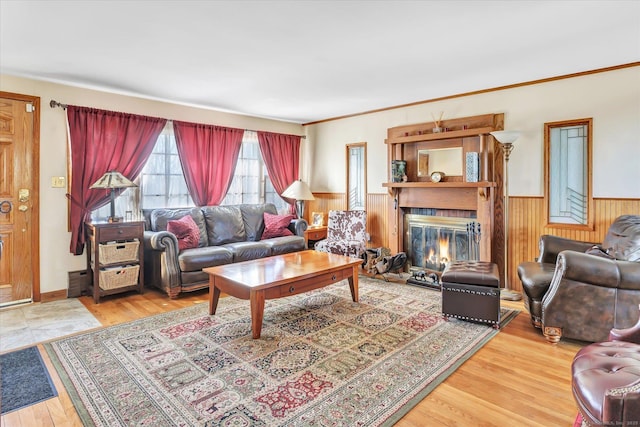 living room featuring hardwood / wood-style flooring, ornamental molding, and wooden walls