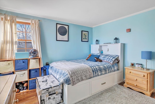 bedroom with crown molding and light hardwood / wood-style flooring