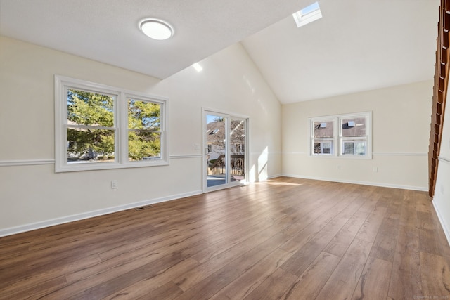 unfurnished living room featuring wood-type flooring and vaulted ceiling with skylight