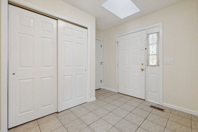 tiled foyer featuring a skylight