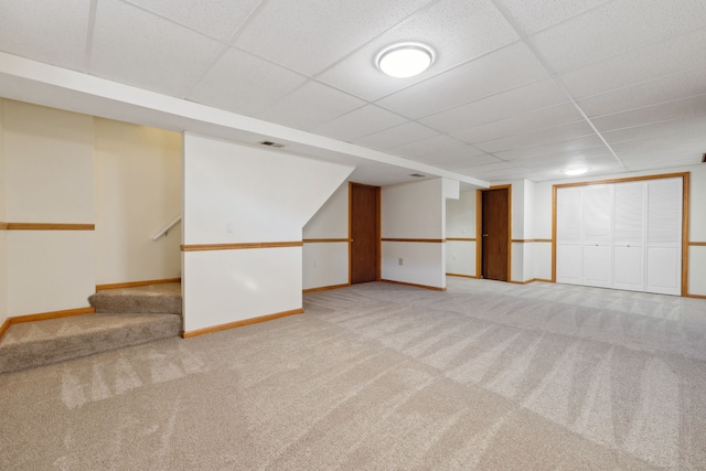 basement with a drop ceiling and carpet floors