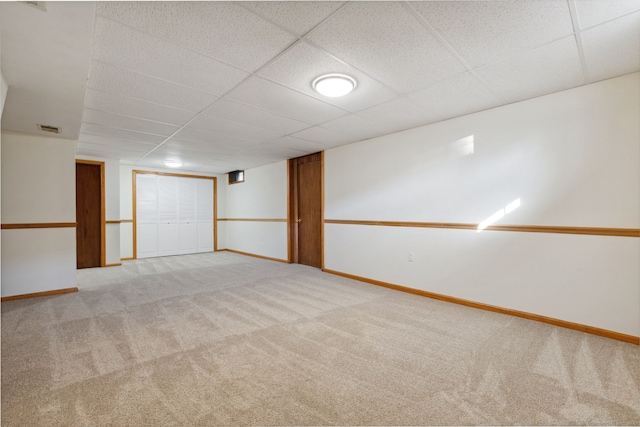 carpeted spare room with a drop ceiling