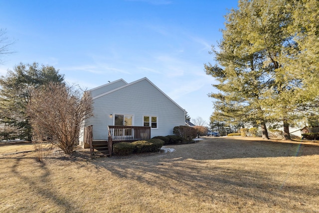 view of home's exterior with a wooden deck and a yard