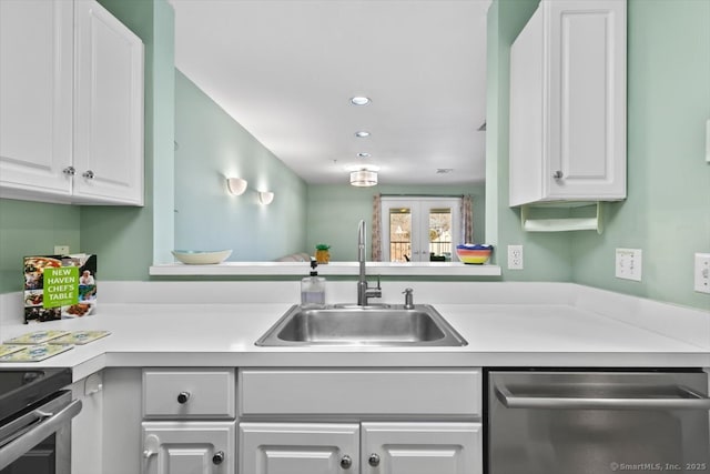 kitchen with dishwasher, sink, and white cabinets