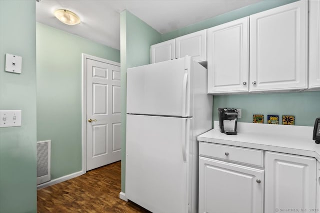 kitchen featuring white cabinetry, dark wood-type flooring, and white refrigerator