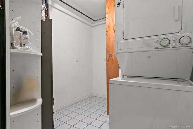 laundry room featuring stacked washer / drying machine and light tile patterned floors