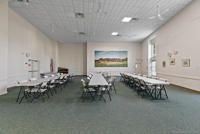 carpeted dining area with a towering ceiling