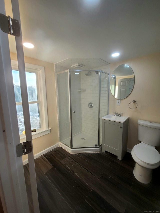 full bath featuring vanity, wood finished floors, a shower stall, and toilet