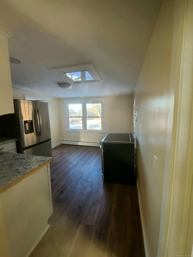 kitchen featuring baseboards, light countertops, baseboard heating, dark wood-type flooring, and stainless steel fridge with ice dispenser