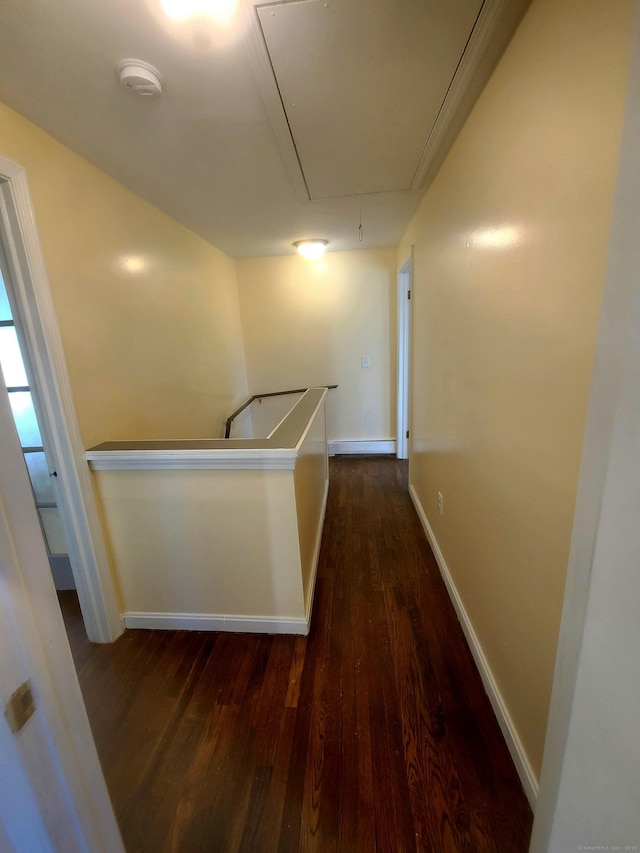 hall featuring attic access, dark wood-style flooring, an upstairs landing, and baseboards