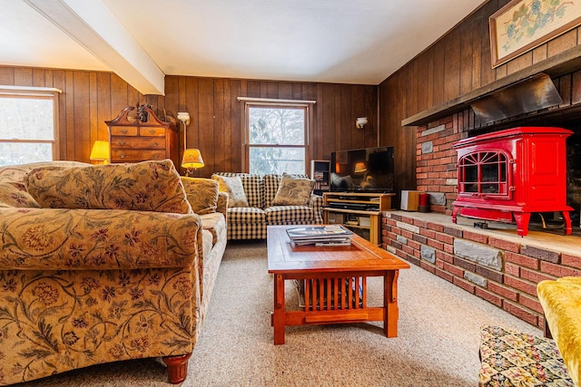 living room with light colored carpet, beamed ceiling, and wood walls