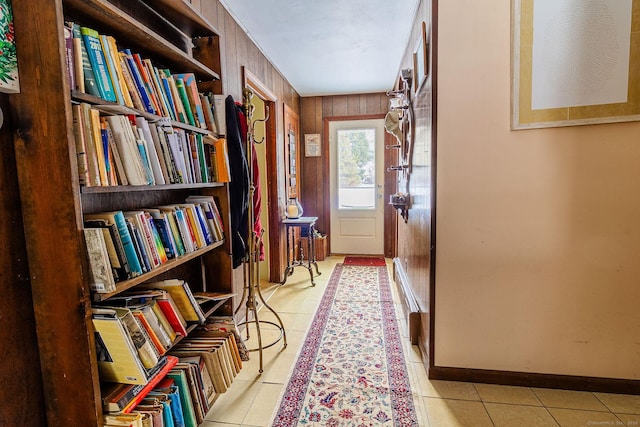 doorway to outside featuring wooden walls and light tile patterned floors