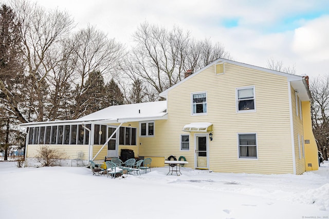 snow covered house with a sunroom