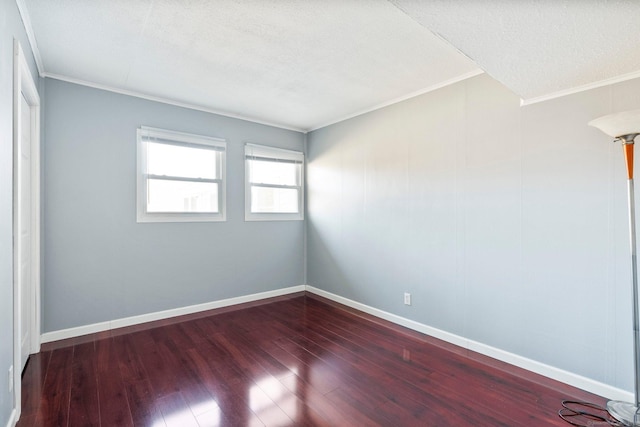 spare room with crown molding, dark wood-type flooring, and a textured ceiling