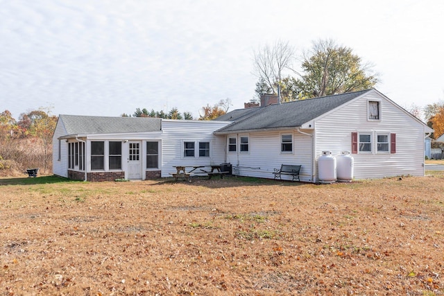 back of house featuring a yard and a sunroom