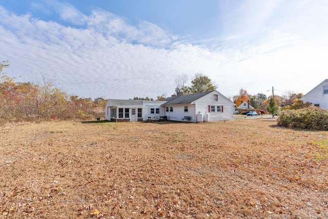 rear view of property featuring a lawn