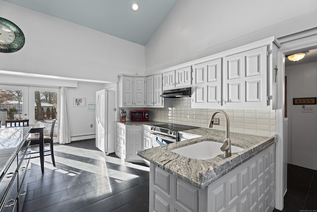 kitchen with sink, stainless steel electric range, backsplash, light stone countertops, and white fridge