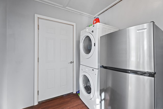 laundry room featuring dark wood-type flooring and stacked washer and clothes dryer