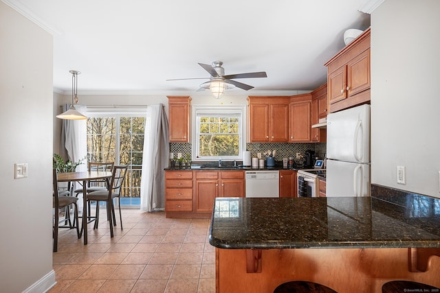 kitchen featuring decorative light fixtures, a kitchen breakfast bar, kitchen peninsula, white appliances, and backsplash