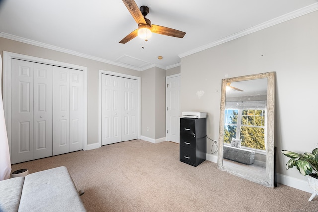 bedroom with multiple closets, ceiling fan, ornamental molding, and light carpet