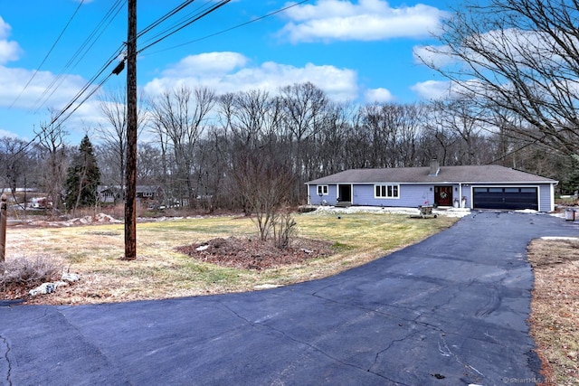 ranch-style home with a garage and a front lawn