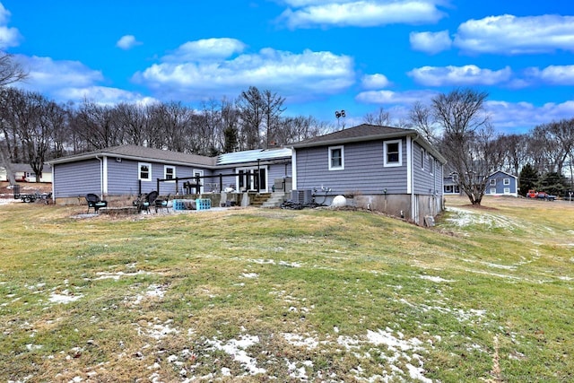 rear view of house featuring a wooden deck and a lawn