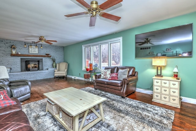 living room featuring dark wood-type flooring and a large fireplace