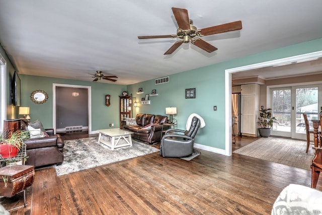 living room featuring ceiling fan and dark hardwood / wood-style flooring