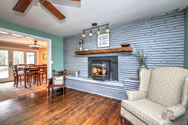 living area featuring french doors, track lighting, ceiling fan, a fireplace, and hardwood / wood-style floors