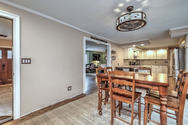 dining area with hardwood / wood-style flooring and ornamental molding