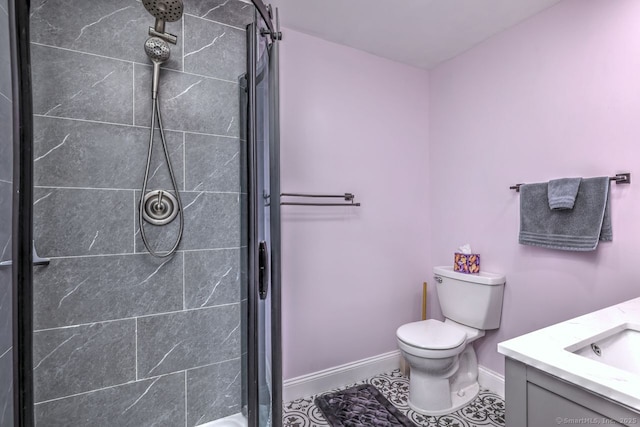 bathroom featuring vanity, toilet, and a tile shower