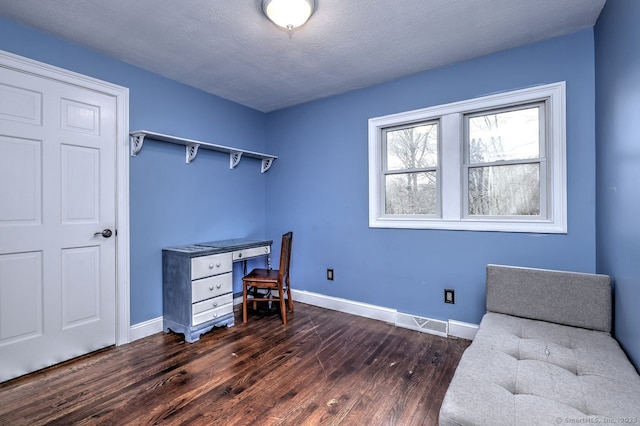 home office with dark hardwood / wood-style flooring and a textured ceiling